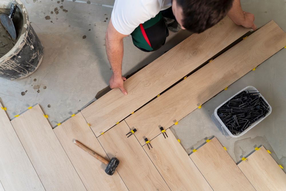 Monteur die bezig is met spc vloer leggen